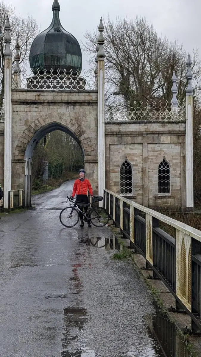 A rider with a bike on the bridge in front of the domed Dromana Gate