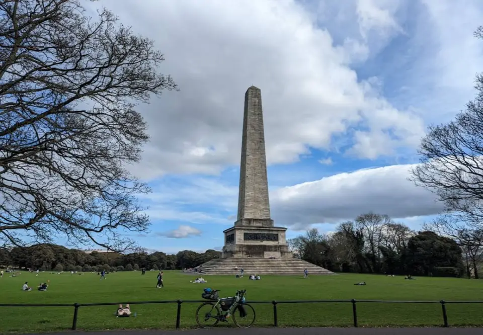 A bike against a railing on the grass in front of the Wellington Monument