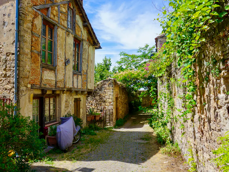 A narrow lane between old stone houses in a French village