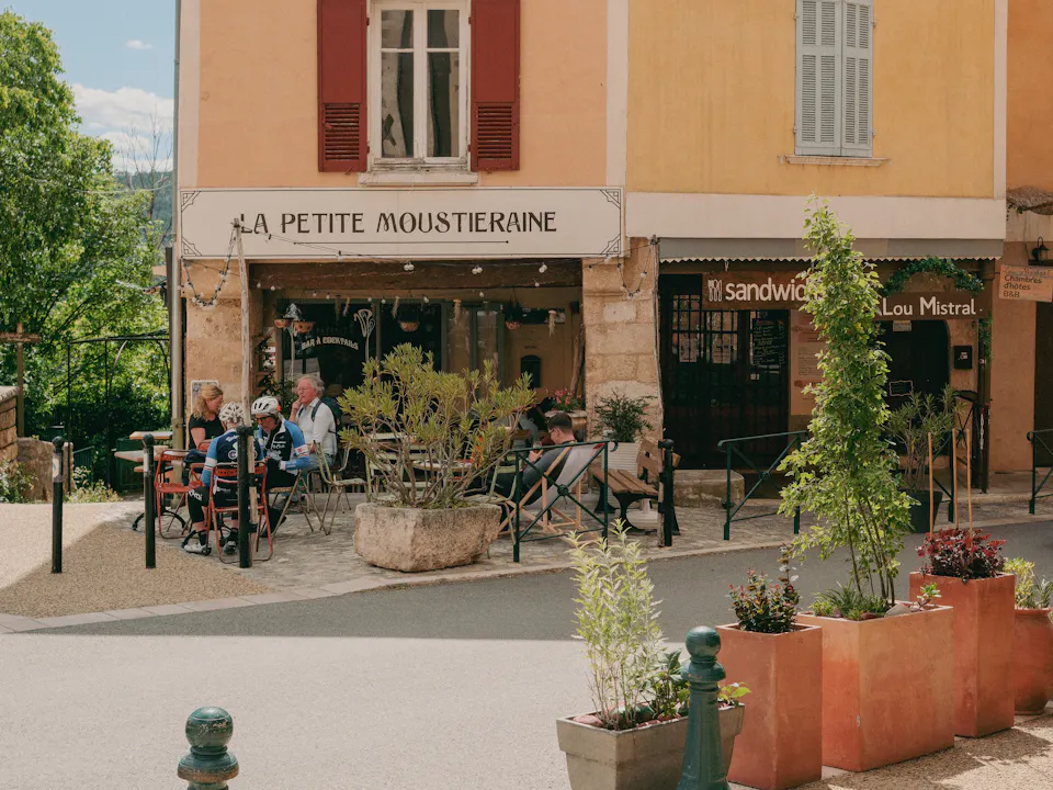 People sitting outside a café on a village square in France