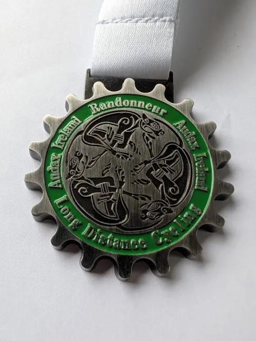 The Audax Ireland randonneur medal, a silver cog around a Celtic knot