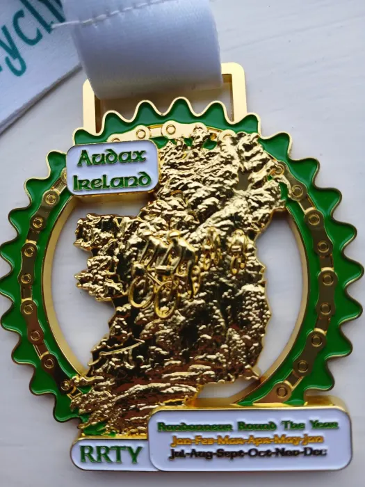 The Audax Ireland RRTY medal, a gold map of Ireland inside a green cog